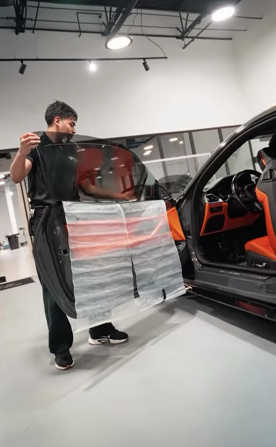 Alejandro installing window tint on a vehicle door